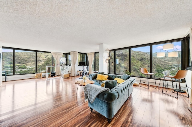 250 Kawaihae St Unit 10E, Honolulu, HI 96825 - living area with a textured ceiling, wood finished floors, a wall of windows, and healthy amount of natural light