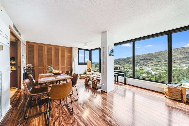 250 Kawaihae St Unit 10E, Honolulu, HI 96825 - dining space with a textured ceiling and wood finished floors