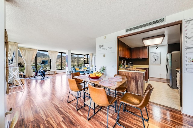 250 Kawaihae St Unit 10E, Honolulu, HI 96825 - dining area featuring light wood-type flooring and a textured ceiling
