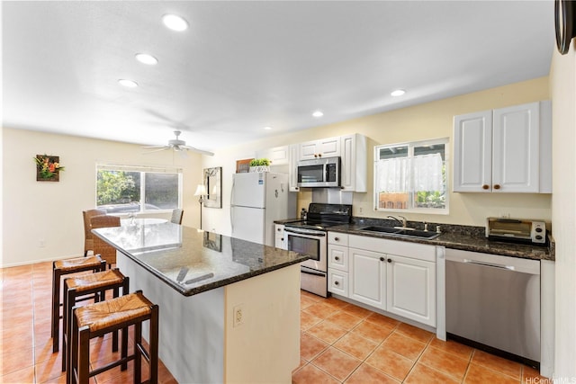 58-292 Kamehameha Hwy, Haleiwa, HI 96712 - kitchen featuring stainless steel appliances, a breakfast bar, light tile patterned floors, white cabinetry, and a kitchen island