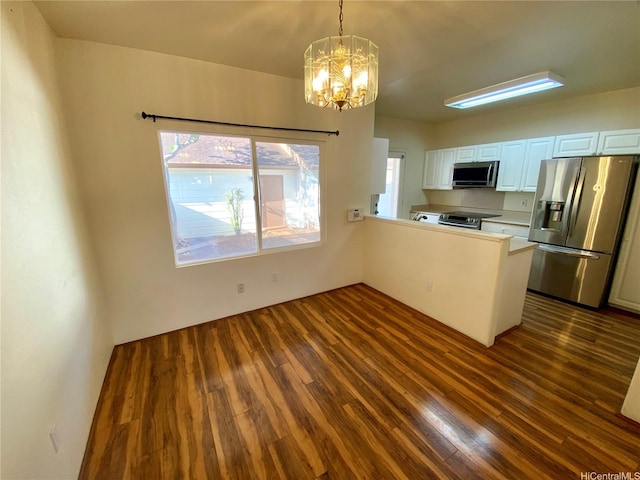 91-1008 Kaiopua St Unit M2, Ewa Beach, HI 96706 - kitchen featuring appliances with stainless steel finishes, dark wood-style floors, a chandelier, and a peninsula
