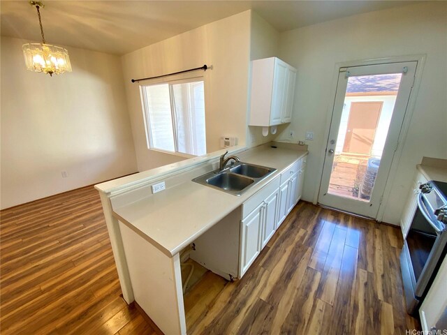 91-1008 Kaiopua St Unit M2, Ewa Beach, HI 96706 - kitchen with a peninsula, white cabinets, dark wood-type flooring, light countertops, and a chandelier