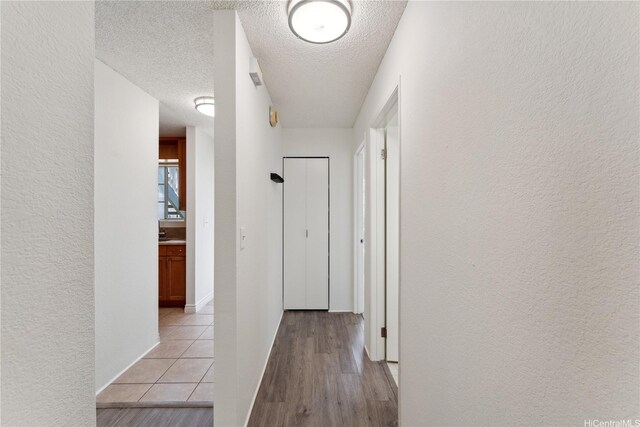 94-1467 Waipio Uka St Unit T103, Waipahu, HI 96797 - hallway with a textured ceiling, a textured wall, and light wood finished floors