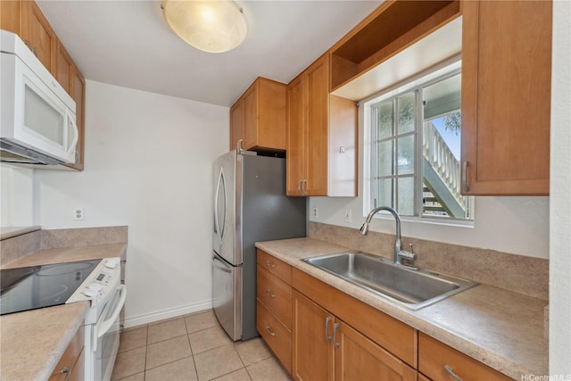94-1467 Waipio Uka St Unit T103, Waipahu, HI 96797 - kitchen with white microwave, range with electric stovetop, a sink, freestanding refrigerator, and light countertops
