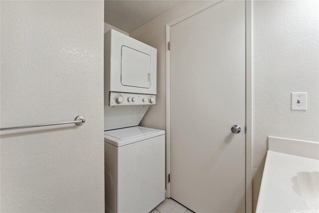 94-1467 Waipio Uka St Unit T103, Waipahu, HI 96797 - washroom featuring estacked washer and dryer, a textured wall, and light tile patterned floors