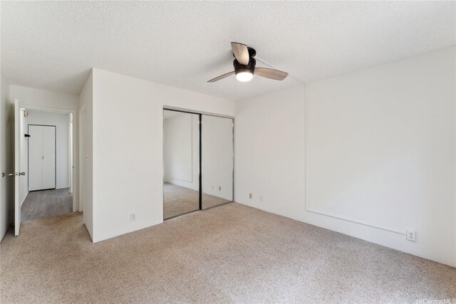 94-1467 Waipio Uka St Unit T103, Waipahu, HI 96797 - unfurnished bedroom featuring light carpet, a closet, a ceiling fan, and a textured ceiling