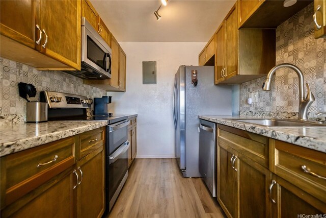 94-1147 Mopua Loop Unit K8, Waipahu, HI 96797 - kitchen featuring appliances with stainless steel finishes, electric panel, light wood-style floors, decorative backsplash, and light stone counters