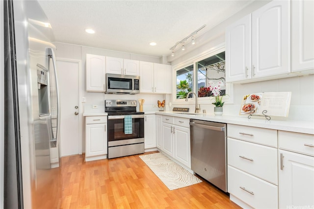 1433 Akanahe Pl, Kailua, HI 96734 - kitchen with appliances with stainless steel finishes, a sink, white cabinets, light wood-type flooring, and light countertops