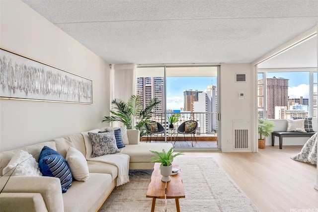 400 Hobron Ln Unit 1807, Honolulu, HI 96815 - living room featuring a skyline view, floor to ceiling windows, wood finished floors, and a textured ceiling