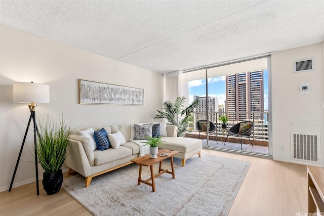400 Hobron Ln Unit 1807, Honolulu, HI 96815 - living room featuring a wall of windows, wood finished floors, a textured ceiling, and a view of city