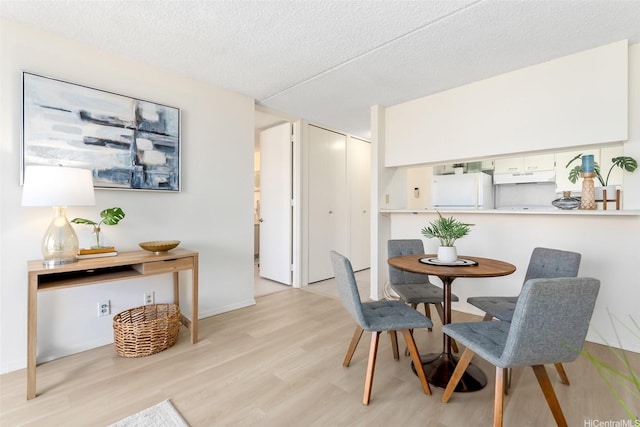 400 Hobron Ln Unit 1807, Honolulu, HI 96815 - dining room with light wood-style floors and a textured ceiling