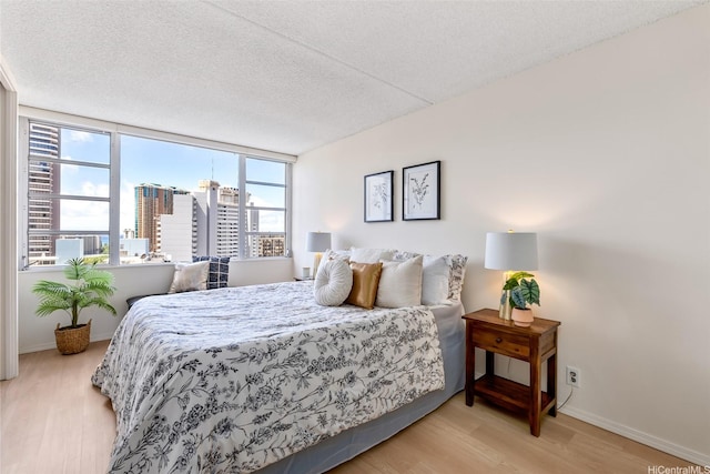 400 Hobron Ln Unit 1807, Honolulu, HI 96815 - bedroom featuring wood finished floors, a textured ceiling, and a view of city