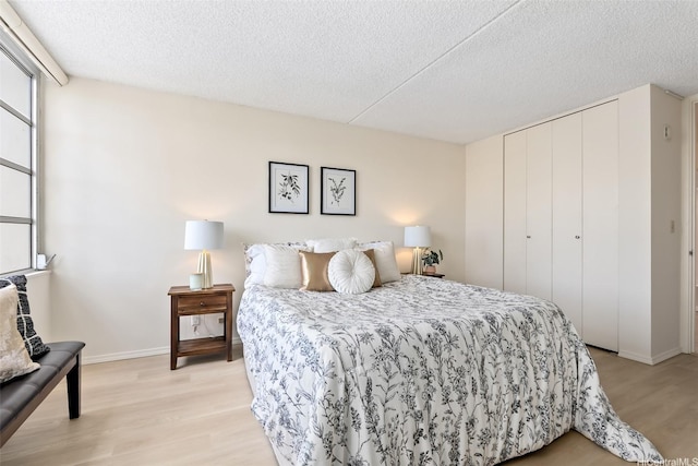 400 Hobron Ln Unit 1807, Honolulu, HI 96815 - bedroom with light wood finished floors, a textured ceiling, and a closet