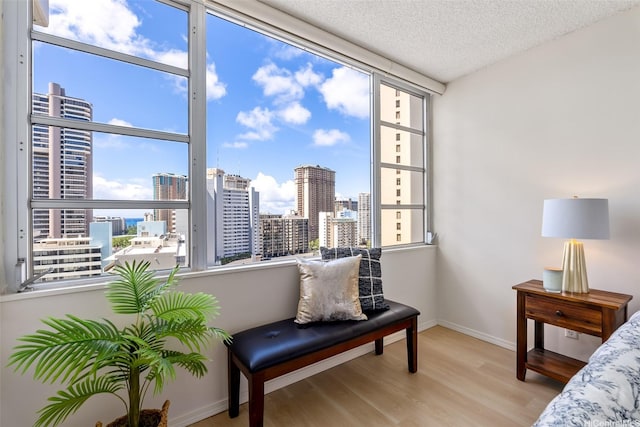 400 Hobron Ln Unit 1807, Honolulu, HI 96815 - bedroom featuring wood finished floors, multiple windows, a view of skyline, and a textured ceiling