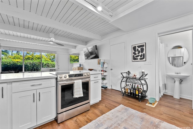 4130 Keanu St Unit 4, Honolulu, HI 96816 - kitchen featuring stainless steel electric range oven, light countertops, white cabinets, beamed ceiling, and light wood-type flooring