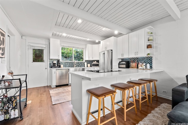 4130 Keanu St Unit 4, Honolulu, HI 96816 - kitchen featuring appliances with stainless steel finishes, a peninsula, light wood-style flooring, a breakfast bar area, and white cabinetry