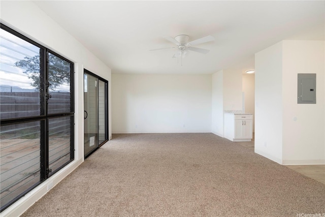 unfurnished room with electric panel, light colored carpet, and ceiling fan