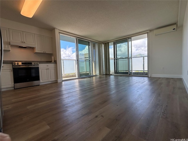 801 S St Unit 1827, Honolulu, HI 96813 - unfurnished living room with dark wood-type flooring, a wall mounted air conditioner, a textured ceiling, a wall of windows, and baseboards