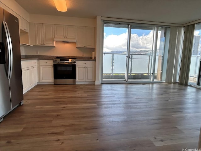 801 S St Unit 1827, Honolulu, HI 96813 - kitchen with appliances with stainless steel finishes, white cabinets, dark countertops, under cabinet range hood, and dark wood-style flooring