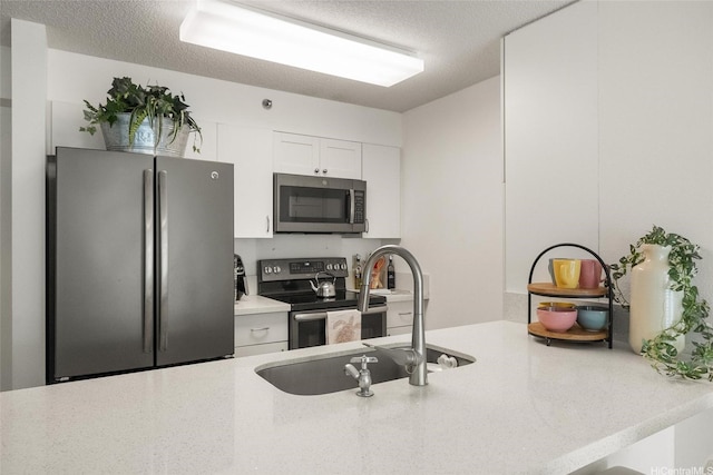 3009 Ala Makahala Pl Unit 214, Honolulu, HI 96818 - kitchen featuring stainless steel appliances, white cabinetry, a peninsula, and a textured ceiling