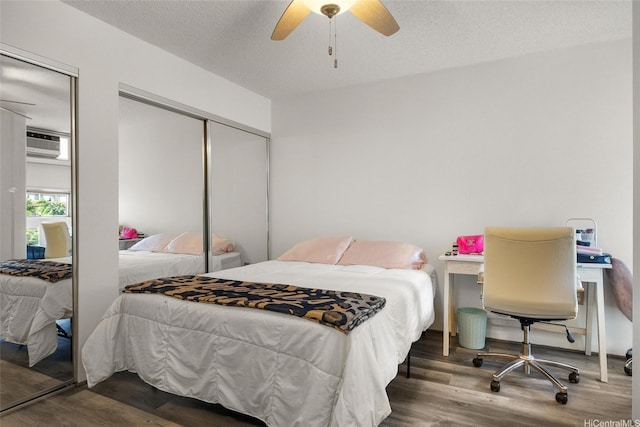 3009 Ala Makahala Pl Unit 214, Honolulu, HI 96818 - bedroom with wood finished floors, ceiling fan, a wall mounted AC, and a textured ceiling