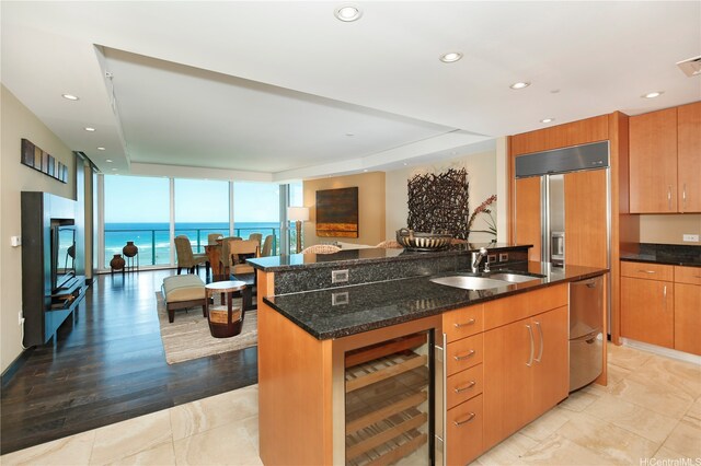 1288 Ala Moana Blvd Unit 18B, Honolulu, HI 96814 - kitchen with beverage cooler, floor to ceiling windows, dark stone counters, an island with sink, and recessed lighting
