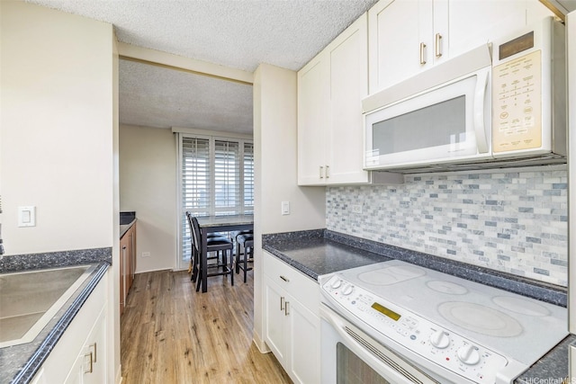 1111 Wilder Ave Pha, Pha, Honolulu, HI 96822 - kitchen with white appliances, dark countertops, light wood finished floors, backsplash, and a textured ceiling