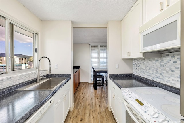 1111 Wilder Ave Pha, Pha, Honolulu, HI 96822 - kitchen featuring white appliances, a textured ceiling, dark countertops, light wood finished floors, and white cabinets