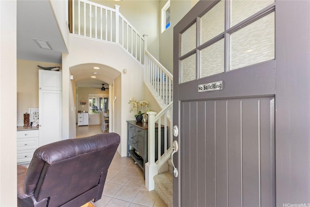 91-6438 Kapolei Pkwy, Ewa Beach, HI 96706 - foyer featuring stairs, light tile patterned floors, a ceiling fan, a high ceiling, and arched walkways