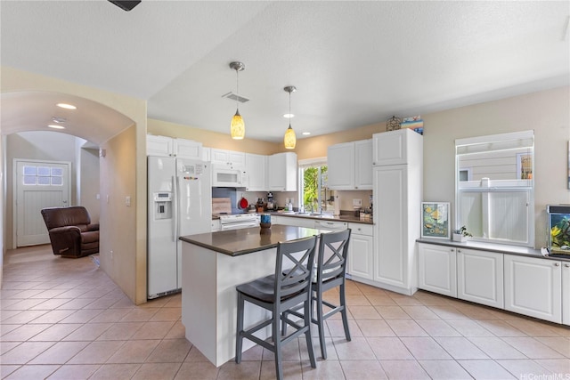 91-6438 Kapolei Pkwy, Ewa Beach, HI 96706 - kitchen with white appliances, dark countertops, light tile patterned floors, and white cabinets