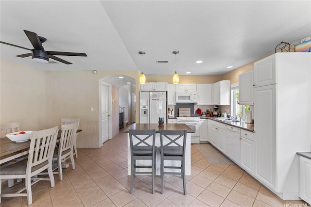 91-6438 Kapolei Pkwy, Ewa Beach, HI 96706 - kitchen with white appliances, a ceiling fan, arched walkways, light tile patterned floors, and white cabinetry