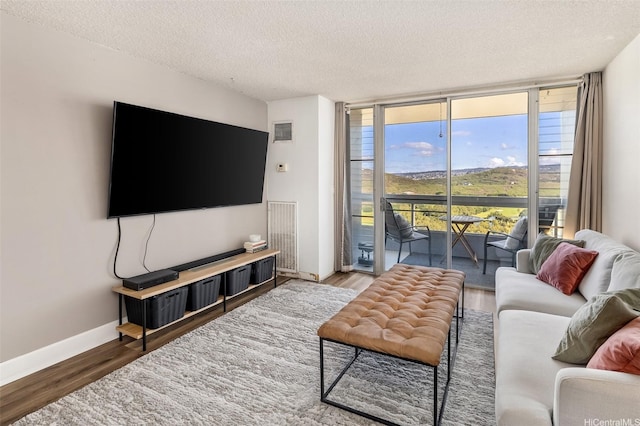 3045 Ala Napuaa Pl Unit 1803, Honolulu, HI 96818 - living room with a wall of windows, wood finished floors, and a textured ceiling