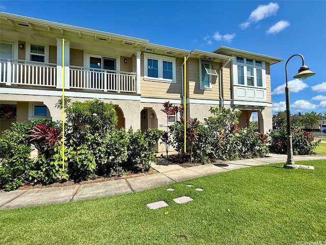 91-2220 Kaiwawalo St Unit 11-1105, Ewa Beach, HI 96706 - view of front of home featuring stucco siding, a front yard, and a balcony