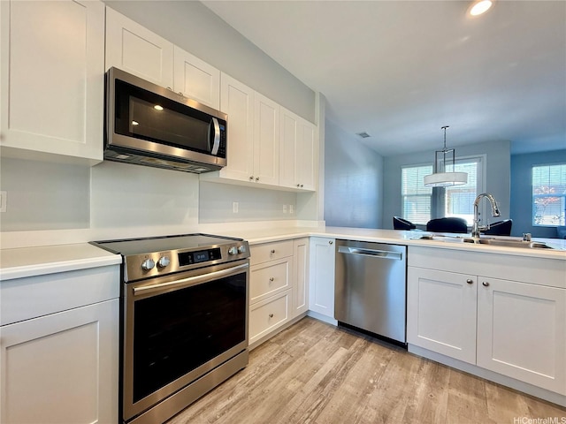 91-2220 Kaiwawalo St Unit 11-1105, Ewa Beach, HI 96706 - kitchen featuring stainless steel appliances, light wood finished floors, light countertops, and white cabinets
