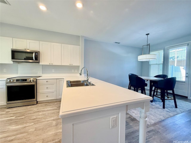 91-2220 Kaiwawalo St Unit 11-1105, Ewa Beach, HI 96706 - kitchen featuring appliances with stainless steel finishes, a peninsula, light wood-style floors, white cabinetry, and light countertops