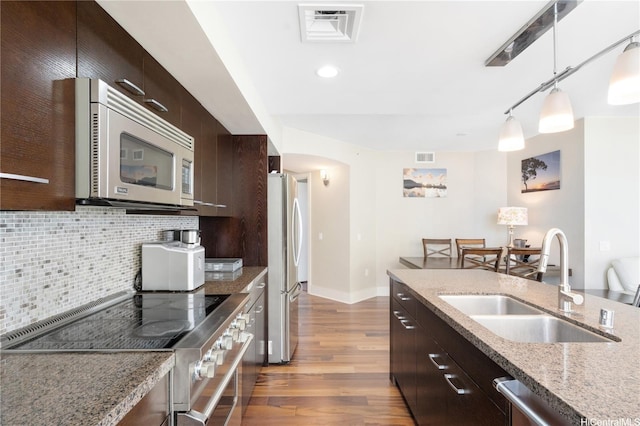 1837 Kalakaua Ave Unit 2001, Honolulu, HI 96815 - kitchen featuring appliances with stainless steel finishes, modern cabinets, wood finished floors, arched walkways, and dark brown cabinets