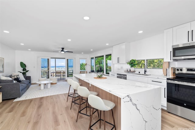 1076 Ilima Dr Unit A, Honolulu, HI 96817 - kitchen featuring appliances with stainless steel finishes, open floor plan, a kitchen island, plenty of natural light, and recessed lighting