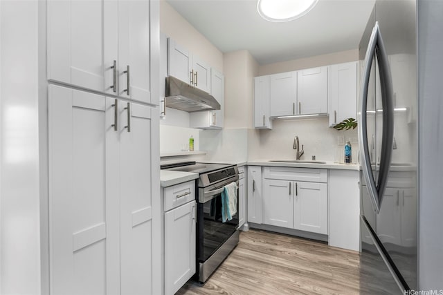731 Amana St Unit 703, Honolulu, HI 96814 - kitchen featuring stainless steel appliances, under cabinet range hood, light countertops, light wood-style floors, and white cabinets
