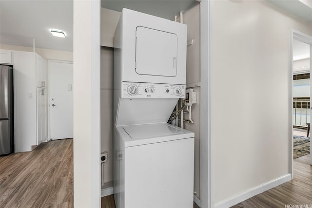 731 Amana St Unit 703, Honolulu, HI 96814 - laundry room featuring stacked washer / drying machine and wood finished floors