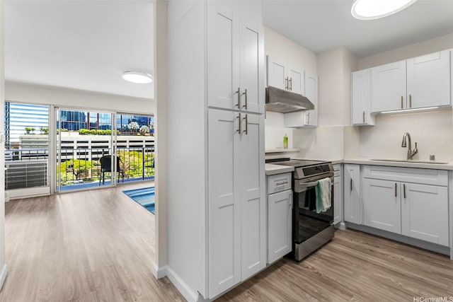 731 Amana St Unit 703, Honolulu, HI 96814 - kitchen with stainless steel range with electric cooktop, under cabinet range hood, light wood-style floors, and light countertops