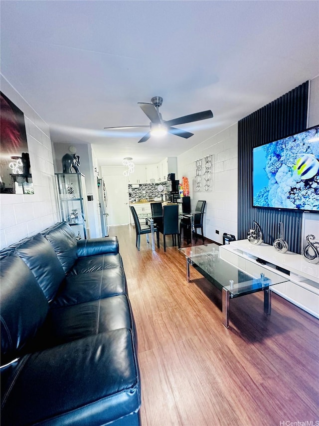 715 Umi St Unit 2B, Honolulu, HI 96819 - living room featuring ceiling fan, light wood-style floors, and concrete block wall