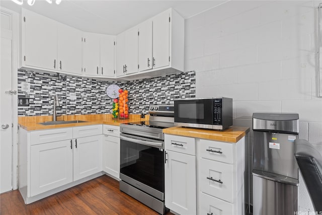 715 Umi St Unit 2B, Honolulu, HI 96819 - kitchen with appliances with stainless steel finishes, wood counters, dark wood-type flooring, and white cabinetry