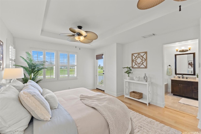 91-1112 Kai Oio St, Ewa Beach, HI 96706 - bedroom with access to exterior, a tray ceiling, light wood finished floors, connected bathroom, and ceiling fan