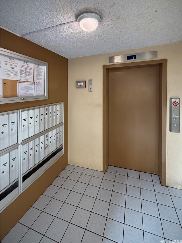 1617 Clark St Unit 404, Honolulu, HI 96822 - hallway with mail area, elevator, a textured ceiling, and light tile patterned floors