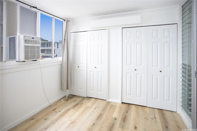 1617 Clark St Unit 404, Honolulu, HI 96822 - unfurnished bedroom featuring wood finished floors, multiple closets, and cooling unit