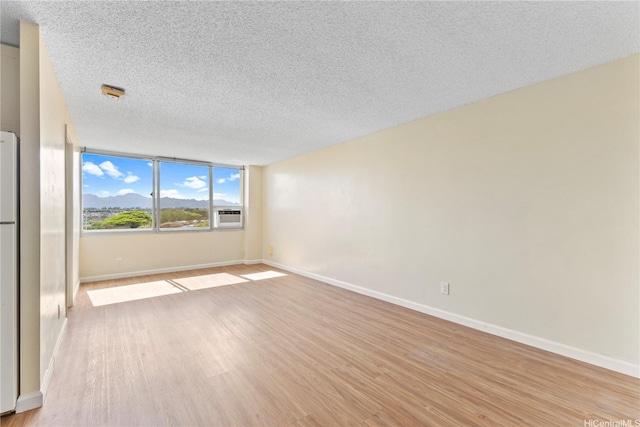 1060 Kamehameha Hwy Unit 801A, Pearl City, HI 96782 - empty room featuring a textured ceiling, light wood finished floors, and a mountain view