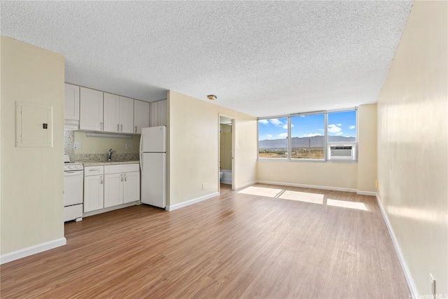 1060 Kamehameha Hwy Unit 801A, Pearl City, HI 96782 - unfurnished living room with light wood finished floors, a textured ceiling, electric panel, and cooling unit
