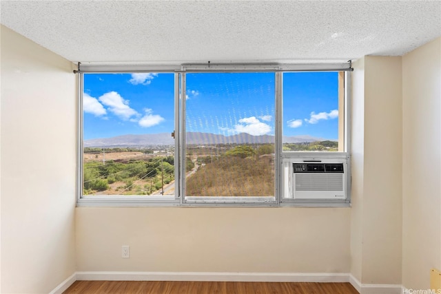 1060 Kamehameha Hwy Unit 801A, Pearl City, HI 96782 - empty room with cooling unit, wood finished floors, a mountain view, and a textured ceiling