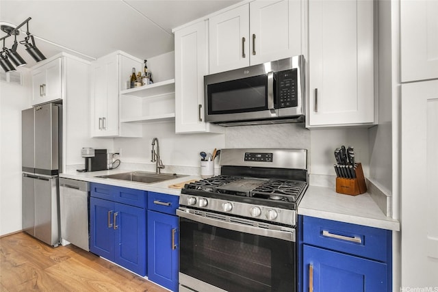 910 Ahana St Unit 508, Honolulu, HI 96814 - kitchen featuring stainless steel appliances, blue cabinetry, open shelves, and light wood-type flooring