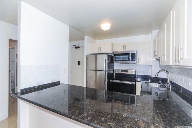 1255 Nuuanu Ave Unit E2804, Honolulu, HI 96817 - kitchen featuring stainless steel appliances, a peninsula, dark stone countertops, and decorative backsplash